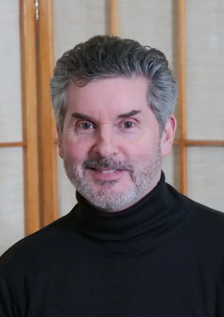 A man with grey hair and a black shirt